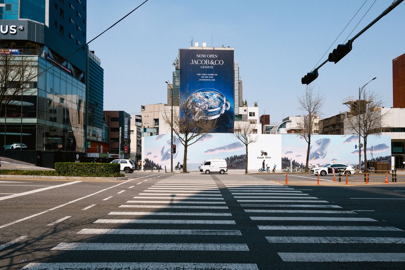 Large watch advertisement at a Seoul intersection with a pedestrian crossing